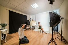 the photographer is setting up his photo shoot in front of two women sitting on chairs