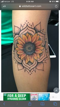 a woman's leg with a sunflower tattoo on the side of her thigh