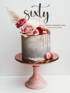 there is a cake with flowers on it and the words sixty written in cursive writing