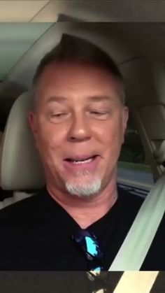 a man sitting in the back seat of a car with his eyes closed and mouth wide open