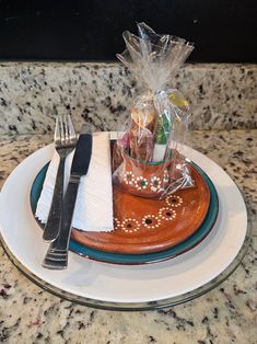 a plate with silverware, napkins and a bag of food on top of it