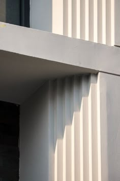 a black and white cat sitting on top of a window sill next to a building