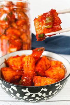 a bowl full of food with chopsticks sticking out of it and some jars in the background