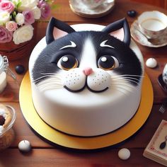 a cake with a black and white cat face on it's side sitting on a table