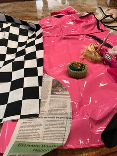 there is a pink plastic bag with a cupcake on it next to a newspaper