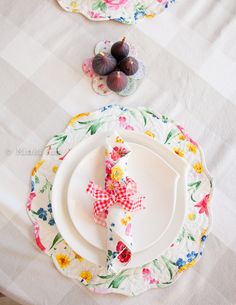 the table is set with plates, napkins, and figurines on it