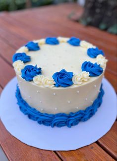 a blue and white cake sitting on top of a wooden table