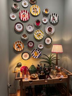 the wall is decorated with many plates and bowls on it's display shelf, along with a lamp