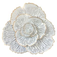 a white flower shaped dish with gold trim