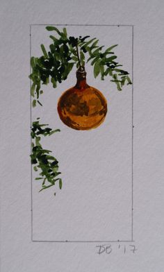 an ornament hanging from a tree branch on a white wall with green leaves