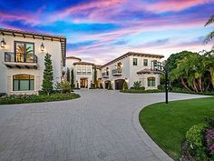 a large white house sitting on top of a lush green field