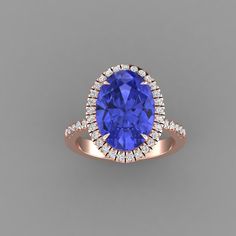 a tan gold ring with an oval blue sapphire surrounded by diamonds