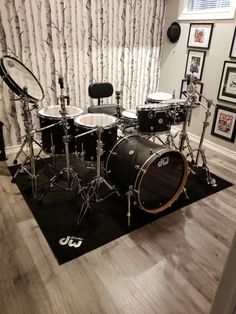 a drum set sitting on top of a hard wood floor in front of a wall