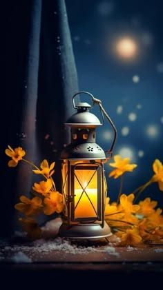 a lit lantern sitting on top of a wooden table next to yellow flowers in the dark