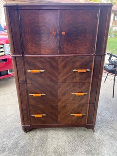 an old wooden dresser is sitting on the ground