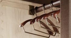 three leather handles hang on a wooden coat rack