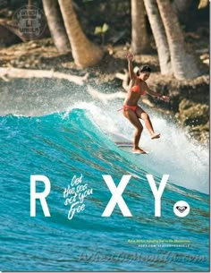 a woman riding a wave on top of a surfboard in front of palm trees