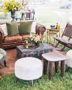 a living room filled with lots of furniture on top of a grass covered field next to trees