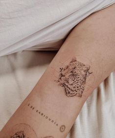 a person with a tattoo on their arm that has a cheetah and other animals