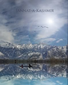 two people in a boat on a lake with mountains in the background and birds flying overhead