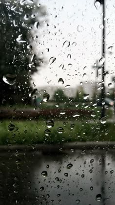 rain drops on the window and street lights in the background, as seen from inside a car