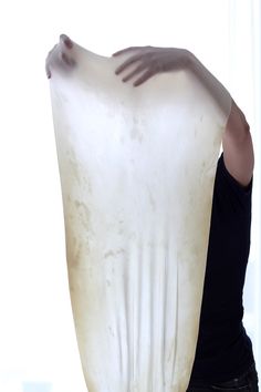 a woman holding a large white object in her hands