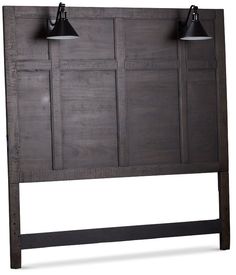 a wooden headboard with two black lamps on it's sides and three dark wood panels