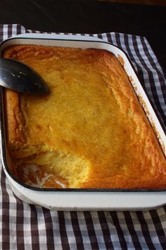 a casserole dish with a spoon in it on a checkered table cloth