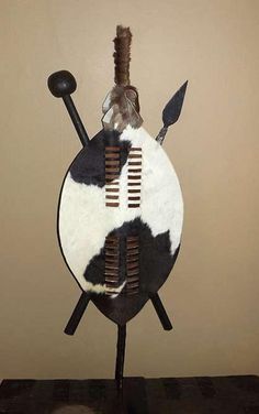 a black and white cow hide sculpture on top of a wooden table next to a wall