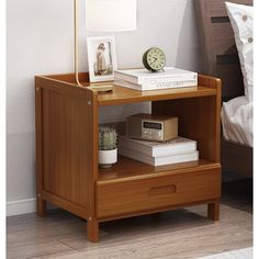 a night stand with two books and a clock on it