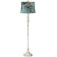 a floor lamp with a peacock print shade on it's side and a white base