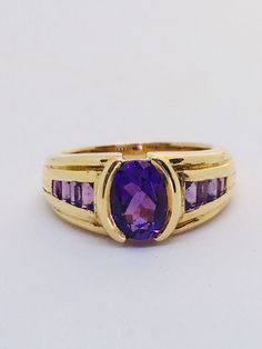 Superb 18ct gold ring set with a large amethyst gemstone. It has a beautiful diamond cut center stone and a cascade of baguette cut Amethysts on both sides. The metaphysical properties of Amethyst are calmness, balance, and peace. Amethyst is a meditative and calming stone that works on the emotional, spiritual, and physical planes. Amethyst has a certain luxurious quality being the royal purple. A natural tranquilizer amethyst relieves an individual from stress and strain, Amethyst is thought o Amethyst Dress, Amethyst Ring Vintage, Amethyst Gem, Calming Stones, Gold Ring Sets, Dress Rings, Baguette Cut, Gems Jewelry, Yellow Gold Ring