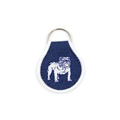 a keychain with a bulldog on it's side and a blue background