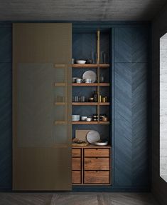 an empty shelf with dishes and cups on it in front of a blue painted wall