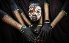 an african woman with painted face and arms