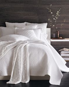 the bed is made with white linens and pillows