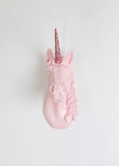 a pink plastic unicorn head with a glittery horn on it's head and the words happy new year above it