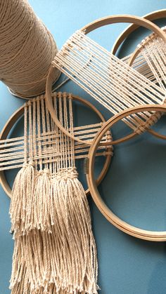 three wooden hoops with yarn on them and two spools of thread next to each other