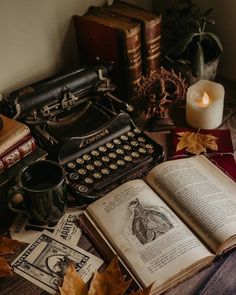 an old fashioned typewriter sitting on top of a table next to books and candles