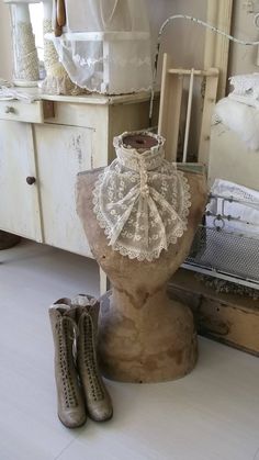 an old fashioned mannequin is sitting on the floor in front of a dresser