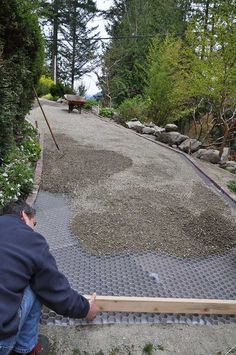 a man sitting on the ground next to a walkway