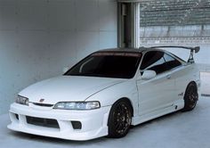 a white car parked in a garage next to a window