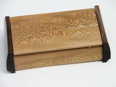 a wooden box sitting on top of a white table next to a knife holder with wood handles