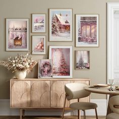 a dining room table with chairs and pictures on the wall above it, along with a vase filled with flowers