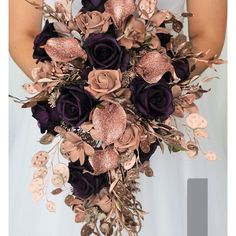 a bridal bouquet with purple roses and gold leaves is shown in front of the bride's dress