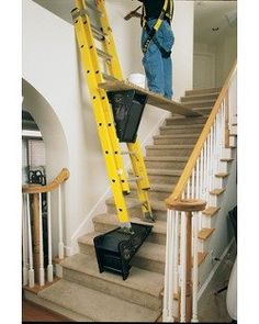 two men are climbing up the stairs with yellow ladders and safety equipment on them