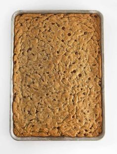 a square cookie in a metal pan on a white surface