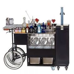 an outdoor bar cart with drinks on the top and two bicycles parked next to it