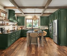 a kitchen with green cabinets and wooden floors