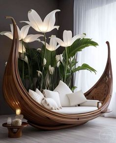 a wooden boat with flowers in it and some pillows on the floor next to it